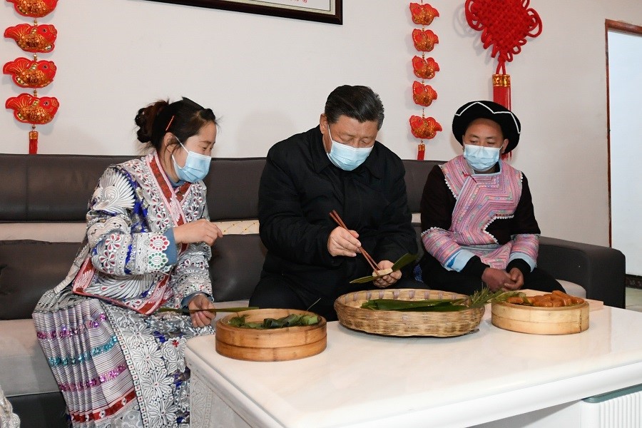 2021年2月3日下午，習(xí)近平在貴州畢節(jié)市黔西縣新仁苗族鄉(xiāng)化屋村苗族村民趙玉學(xué)家，同一家人邊聊家常邊制作當(dāng)?shù)貍鹘y(tǒng)節(jié)日食品黃粑。新華社記者 李學(xué)仁 攝